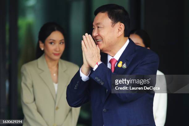 Former Thai prime minister Thaksin Shinawatra and his daughters Pintongtha Kunakornwong and Paetongtarn Shinawatra greet supporters as he arrives at...