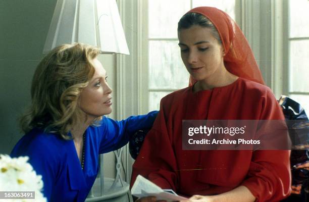 Faye Dunaway approaches Natasha Richardson in a scene from the film 'The Handmaid's Tale', 1990.