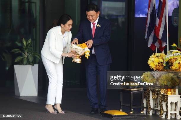 Former Thai prime minister Thaksin Shinawatra and his daughter Paetongtarn Shinawatra prepare offerings as he prepares to pay respects to a portrait...
