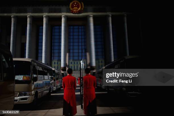 Hotel guide for delegates waits outside the Great Hall of the People during a presidium meeting after a pre-opening session of the National People's...