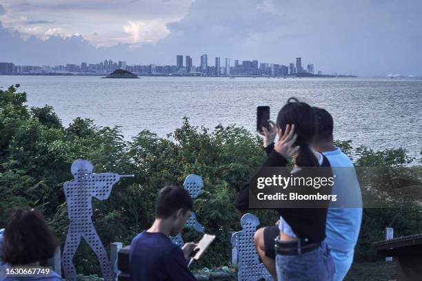 Buildings in Xiamen on mainland China stand across the Taiwan Strait from tourists on Lieyu Island in Kinmen, Taiwan, on Monday, Aug. 21, 2023....