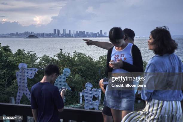 Buildings in Xiamen on mainland China stand across the Taiwan Strait from tourists on Lieyu Island in Kinmen, Taiwan, on Monday, Aug. 21, 2023....