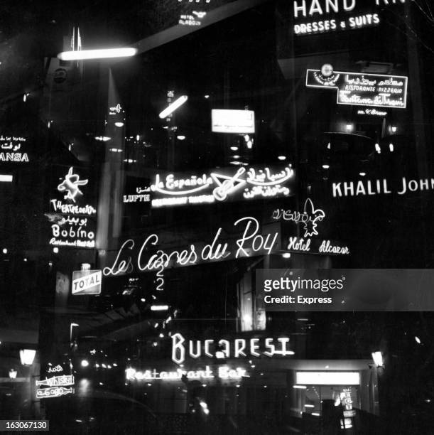 Illuminated signage displayed in many colors and languages across the city to attract the night life crowd in Beirut Lebanon, 1955.