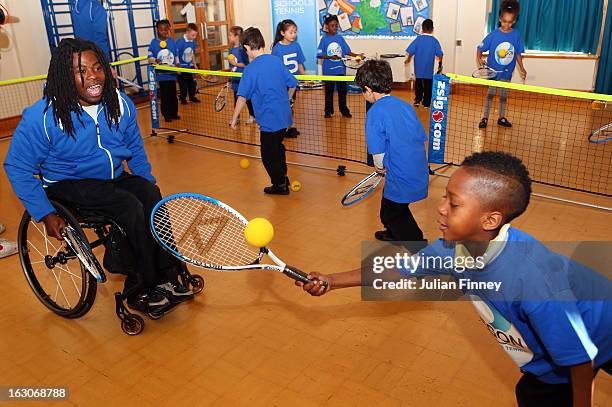 Ade Adepitan watches a child play tennis at the Britannia Village Primary School on March 4, 2013 in London, England. Aegon Schools Tennis Programme...