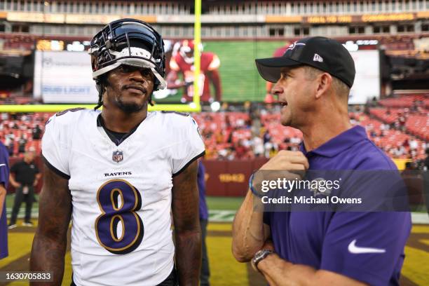 Lamar Jackson of the Baltimore Ravens chats with head coach John Harbaugh of the Baltimore Ravens during an NFL preseason game at FedExField on...