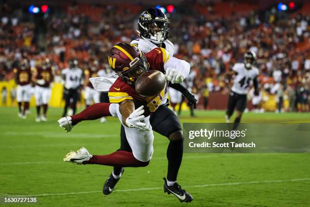 Mitchell Tinsley of the Washington Commanders attempts a catch against Tae Hayes of the Baltimore Ravens during the second half of the preseason game...