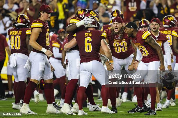 Joey Slye of the Washington Commanders celebrates with teammates after kicking the go-ahead field goal against the Baltimore Ravens during the second...