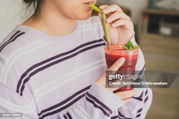 woman drinking beetroot smoothie - remolacha fotografías e imágenes de stock
