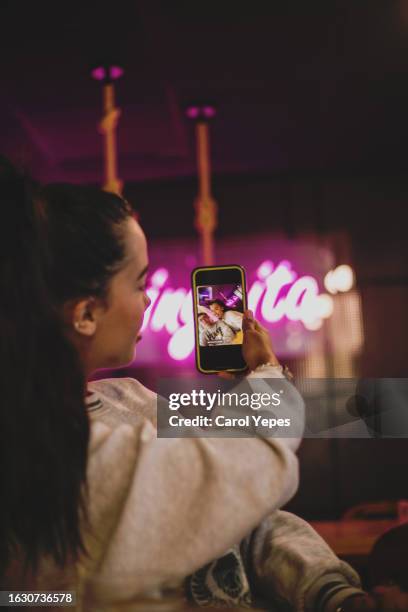 young woman poses as she takes a selfie into a coffee bar - kroppsmedveten bildbanksfoton och bilder