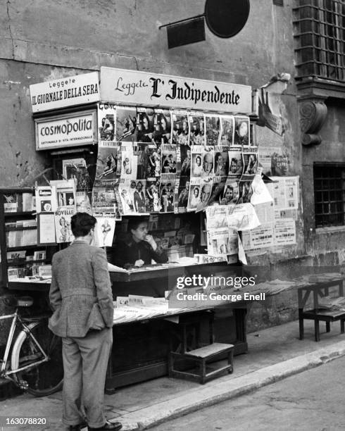 Man standing at a news stand in Rome, Italy, 1955.