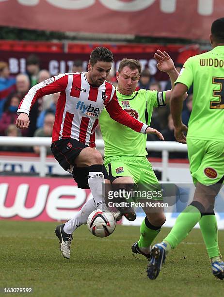 Arron Davies of Exeter City attempts to control the ball under pressure from Kelvin Langmead of Northampton Town during the npower League Two match...