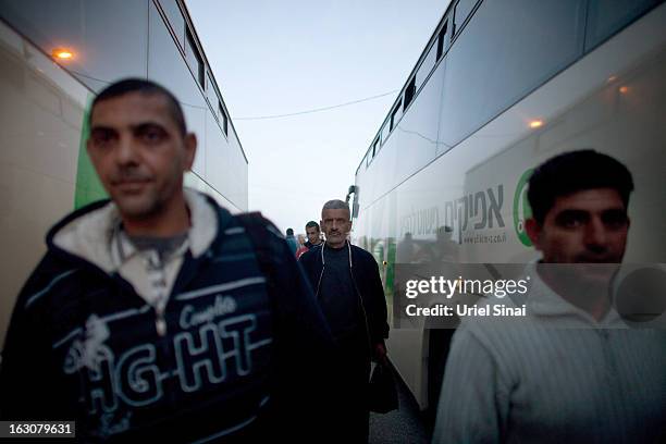 Palestinians board a bus as a new line is made available by Israel to take Palestinian labourers from the Israeli army crossing of Eyal, near the...