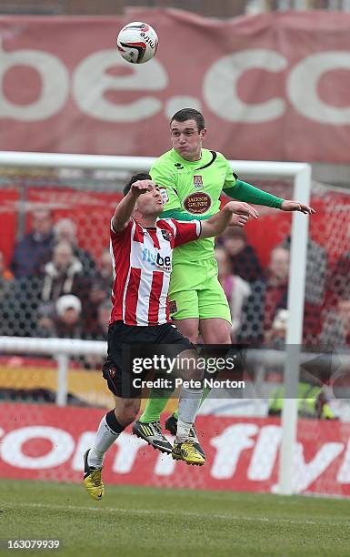 Lee Collins of Northampton Town heads the ball away from Jake Gosling of Exeter City during the npower League Two match between Exeter City and...