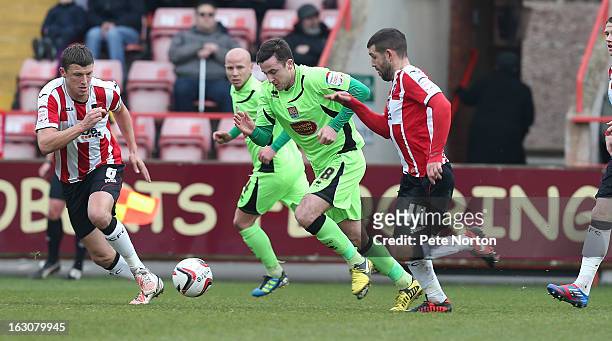 Roy O'Donovan of Northampton Town moves forward with the ball watched by Danny Coles and Tommy Doherty of Exeter City during the npower League Two...