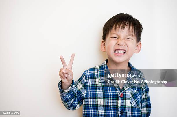 the little boy than the victory sign - boy brown hair stock pictures, royalty-free photos & images