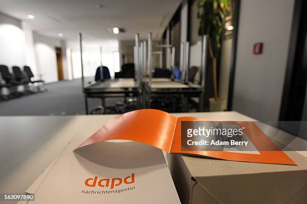 Box of brochures about the German news agency dapd lies on a table in a room full of upturned furniture in the company's offices on March 4, 2013 in...