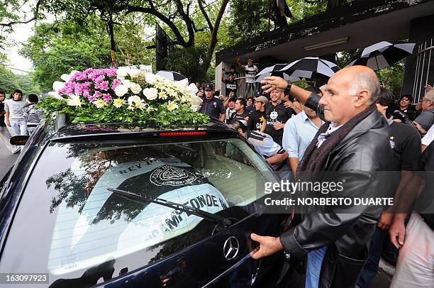 Fans and heads of Paraguay's Olimpia footbal prepare to carry the coffin of legendary Uruguayan footballer and coach Luis Cubilla, for his wake at...