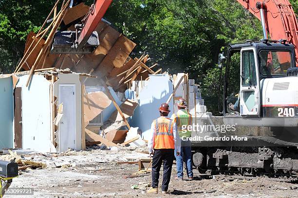 Workers observe the demolition of the home where a sinkhole swallowed Jeffrey Bush on March 4, 2013 in Seffner, Florida. Jeff Bush, presumed dead...