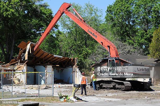 Workers observe the demolition of the home where a sinkhole swallowed Jeffrey Bush on March 4, 2013 in Seffner, Florida. Jeff Bush, presumed dead...