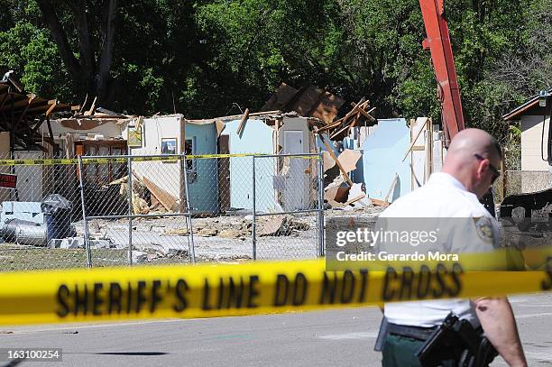 Police officer walks in front of the home where a sinkhole swallowed Jeffrey Bush on March 4, 2013 in Seffner, Florida. Jeff Bush, presumed dead...