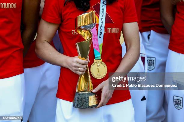 Football player Ivana Andrés holds the Women's World Cup trophy as Spanish Prime Minister Pedro Sanchez receives the Spanish women’s national...