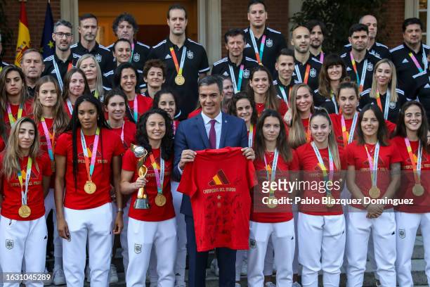 Spanish Prime Minister Pedro Sanchez poses for the media with a t-shirt signed by the Spanish women’s national football team during a reception to...