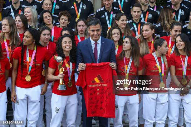 Spanish Prime Minister Pedro Sanchez poses for the media with a t-shirt signed by the Spanish women’s national football team during a reception to...