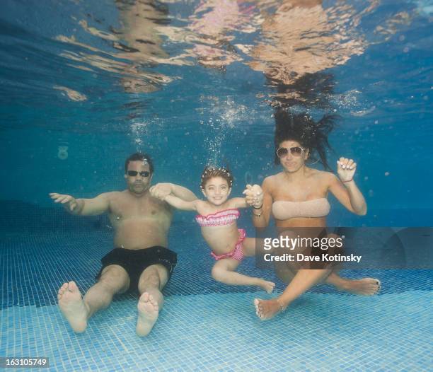 Joe Giudice, Teresa Giudice and daughter Audriana Giudice pose underwater at Majestic Resort on March 4, 2013 in Punta Cana, Dominican Republic.