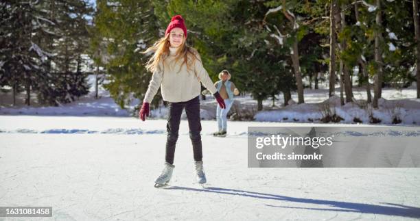 portrait of smiling girl ice skating - ice skater stock pictures, royalty-free photos & images