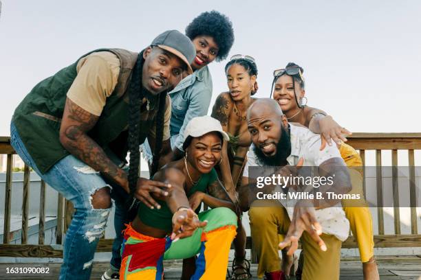 group portrait of african american friends at rooftop party - かがむ 人 横 ストックフォトと画像