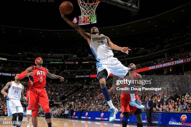 Corey Brewer of the Denver Nuggets lays in a shot against Josh Smith of the Atlanta Hawks and Anthony Tolliver of the Atlanta Hawks at the Pepsi...