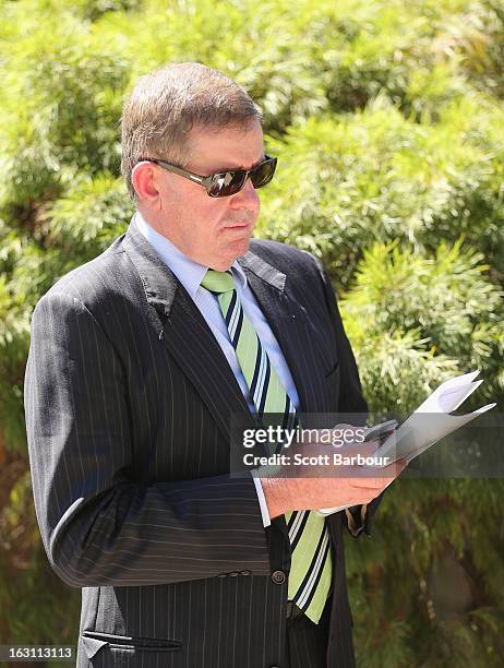 Former Speaker, Peter Slipper uses his mobile phone as he leaves the State Funeral for former speaker Joan Child on March 5, 2013 in Melbourne,...