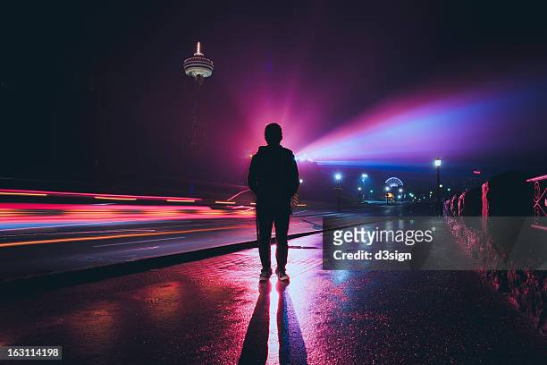 silhouette of man with spectacular colorful light - lange sluitertijd stockfoto's en -beelden