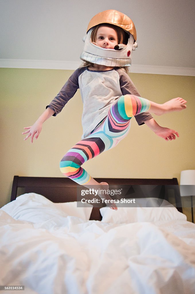 Young Girl in Costume Jumping on Bed