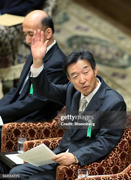 Kikuo Iwata, professor of economics at Gakushuin University and nominee for deputy governor of the Bank of Japan , right, raises his hand as Hiroshi...