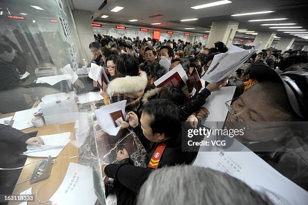 People crowd into the Nanjing Municipal Real Estate Trading Centre looking to sell property ahead of a tax policy change on March 4, 2013 in Nanjing,...