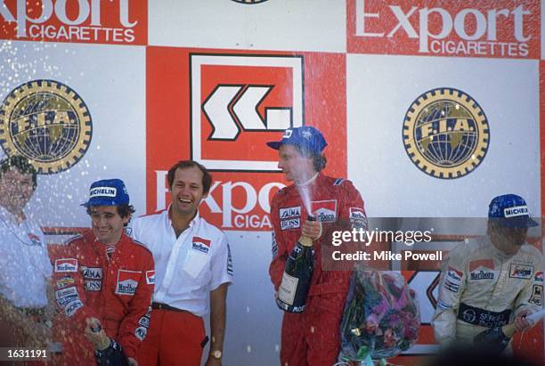 McLaren TAG drivers Alain Prost and Niki Lauda of Austria partake in the traditional champagne celebration after the Portuguese Grand Prix at the...