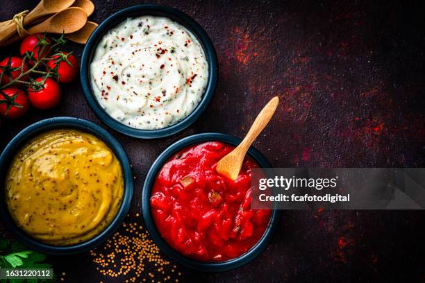 tomato sauce, dijon mustard an mayonnaise shot from above on dark table. copy space - sauce stock pictures, royalty-free photos & images