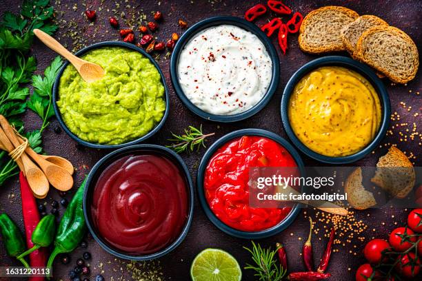 set of five dip sauces shot from above on dark table - dipset stockfoto's en -beelden