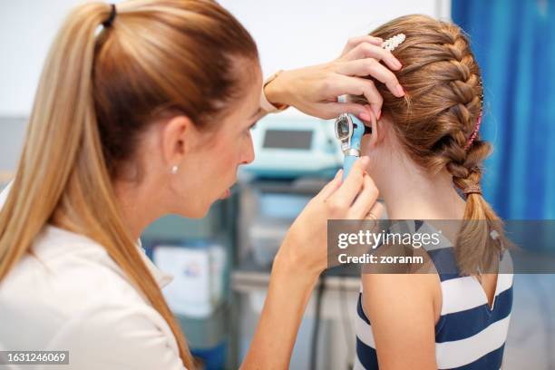 otolaryngologist examining girl patient's ear with otoscope in the office - otoscope bildbanksfoton och bilder