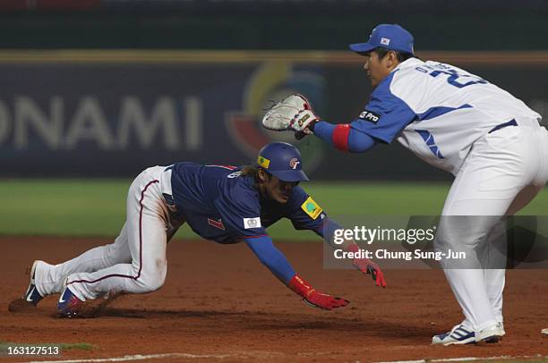 Yang Dai-Kang of Chinese Taipei slides back to fiirst base as Lee Dae-Ho of South Korea tags in the third inning during the World Baseball Classic...