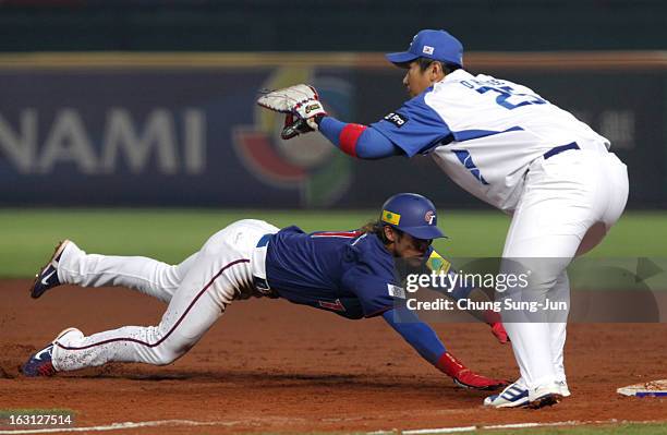 Yang Dai-Kang of Chinese Taipei slides back to fiirst base as Lee Dae-Ho of South Korea tags in the third inning during the World Baseball Classic...