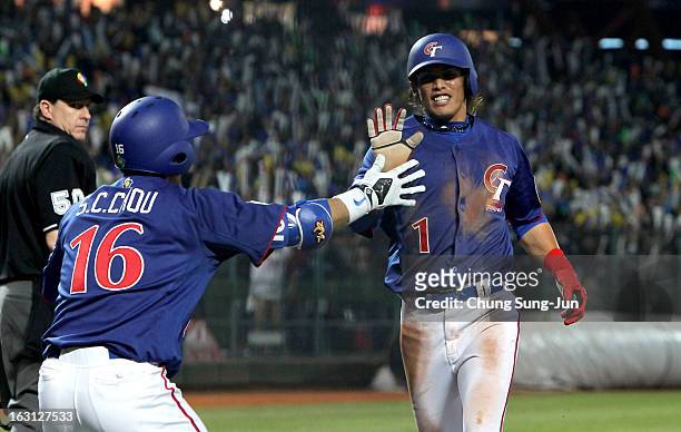 Yang Dai-Kang of Chinese Taipei celebrates with his team mate Chou Szu-Chi in the third inning during the World Baseball Classic First Round Group B...