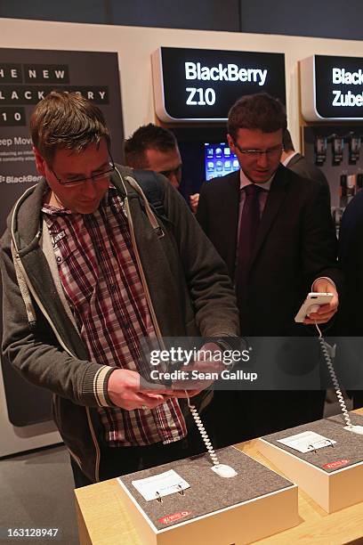 Visitors try out the Blackberry Z10 smartphone, which is the Germany version of the Blackberry 10, at the Vodafone stand at the 2013 CeBIT technology...