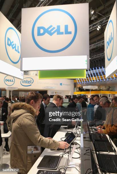 Visitors try out the latest laptop computers at the Dell stand at the 2013 CeBIT technology trade fair on March 5, 2013 in Hanover, Germany. CeBIT...