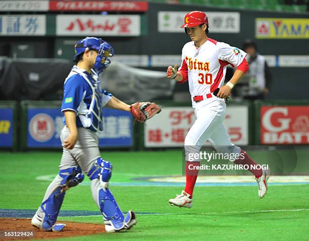 China's Chu Fujia runs to the home-plate as Brazil's catcher Diego Franca looks on following a bases-loaded walk by pitcher Thyago Vieira during the...