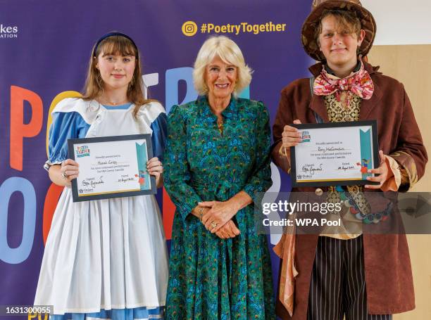 Queen Camilla poses with Rory Brandreth-McConnachie and Alice Hannah Griggs as she attends a 'Poetry Together' recital and tea party at Fielding...