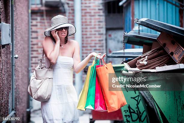 baffled lost shopper calls for help near garbage bins - trash bag dress stock pictures, royalty-free photos & images