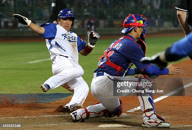 Jeong Keun-Woo of South Korea slides into the home base in the fifth inning during the World Baseball Classic First Round Group B match between...