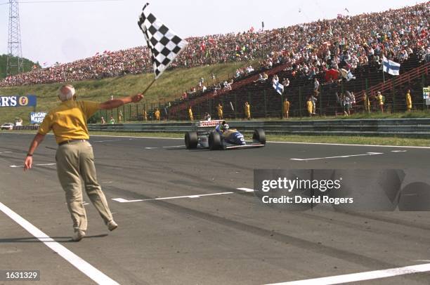 Damon Hill of Great Britain races past the chequered flag in his Williams Renault to win the Hungarian Grand Prix at the Hungaroring circuit in...